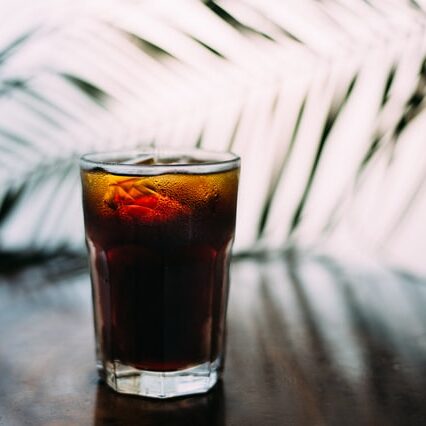 glass of cold brew coffee with palms in background, tips for making cold brew coffee