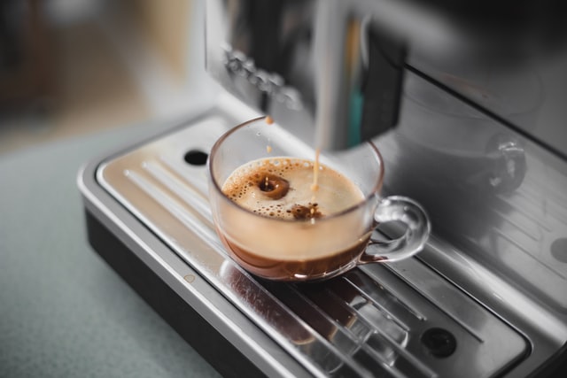 close up of espresso brewing into glass mug