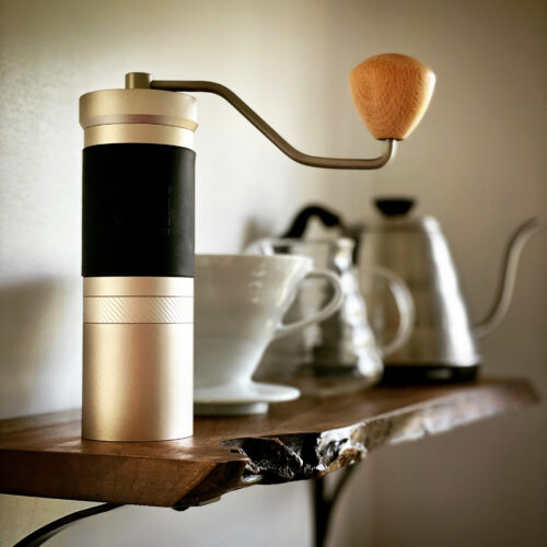jx pro grinder on wooden shelf beside pour over tools, 1zpresso grinder