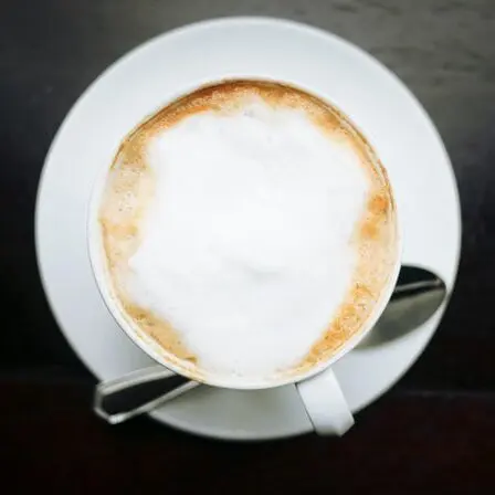 frothy cappuccino in white mug on black surface, how to froth milk without a frother