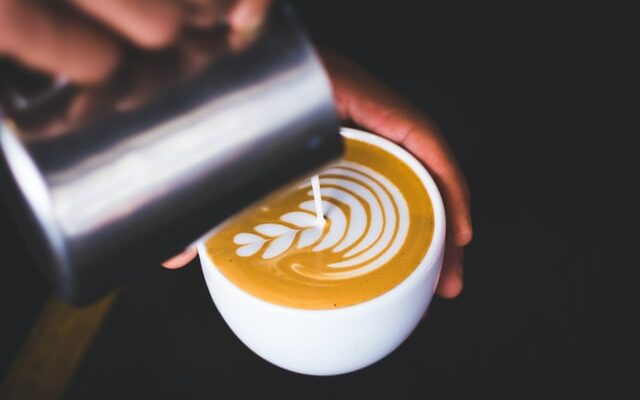 up close shot of barista pouring latte art, how to froth milk without a frother