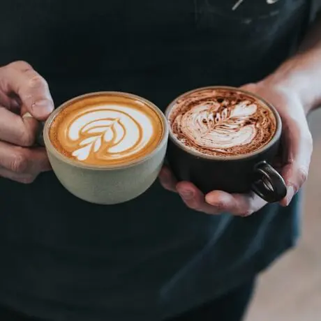 man holding a latte and a mocha with black shirt, latte vs. mocha