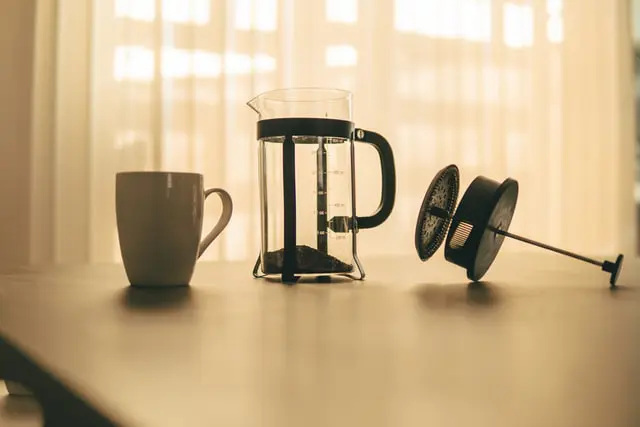 How To Use French Press Coffee Makers + The #1 Mistake 3 disassembled French press beside white coffee mug on counter