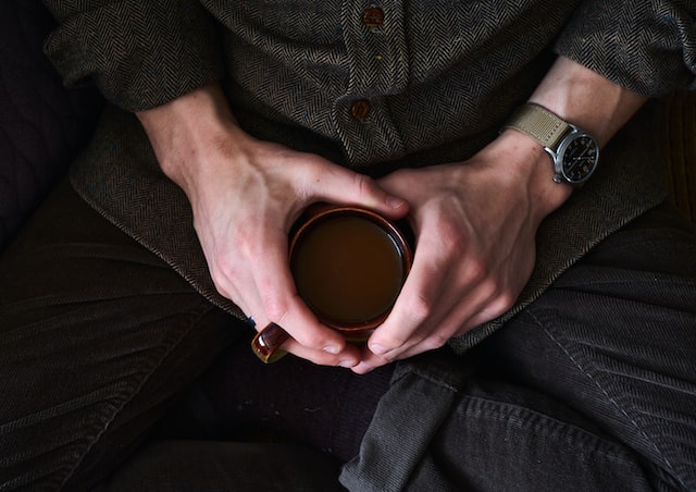 man's hands holding a cup of coffee in lap, drip coffee ratio, drip coffee maker, coffee machine
