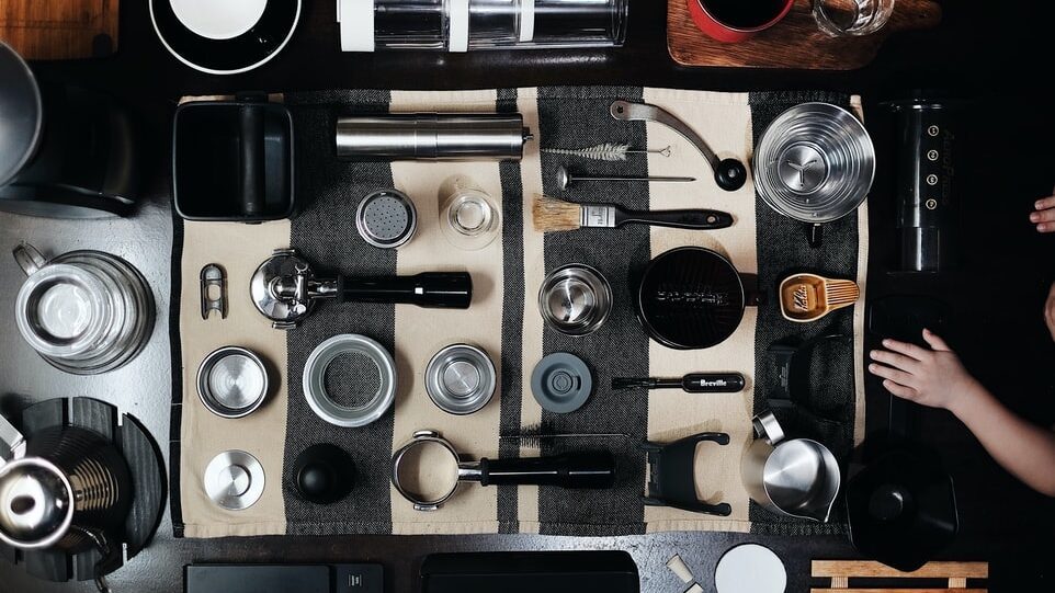 flat lay of coffee equipment on dark grey background, pour over vs. aeropress