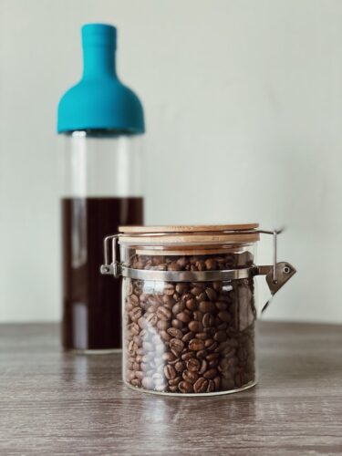 What Are The Best Coffee Beans For Cold Brew? Try 1 Of These 2 glass canister of coffee beans with blue bottle cold brewer in background
