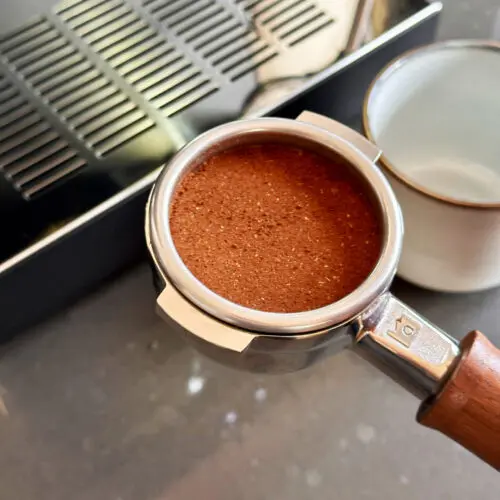 portafilter with ground coffee and wooden handle