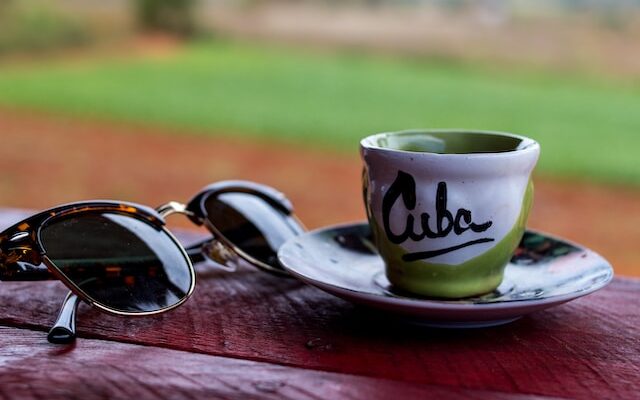 small cuba espresso cup beside sunglasses, coffee colada