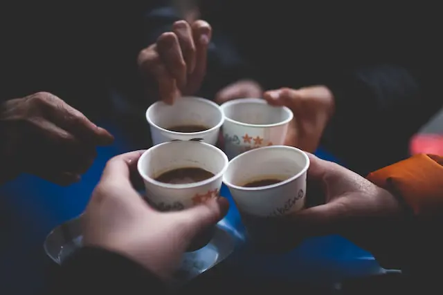 four hands toasting colada coffee cups