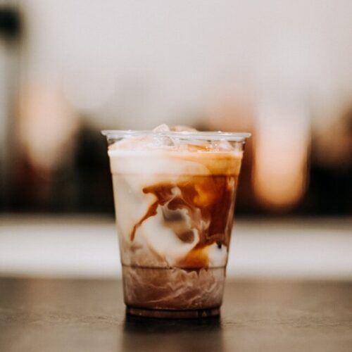 cup of iced coffee with milk swirling, lower acid coffee