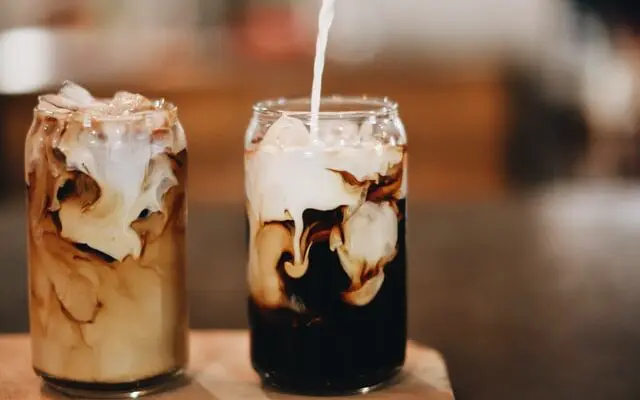 milk pouring into two glasses of iced coffee, difference between iced coffee and cold brew