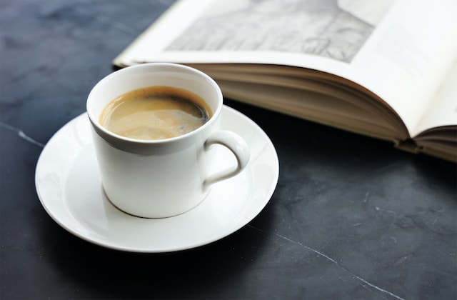 americano or long black on grey table beside an open book